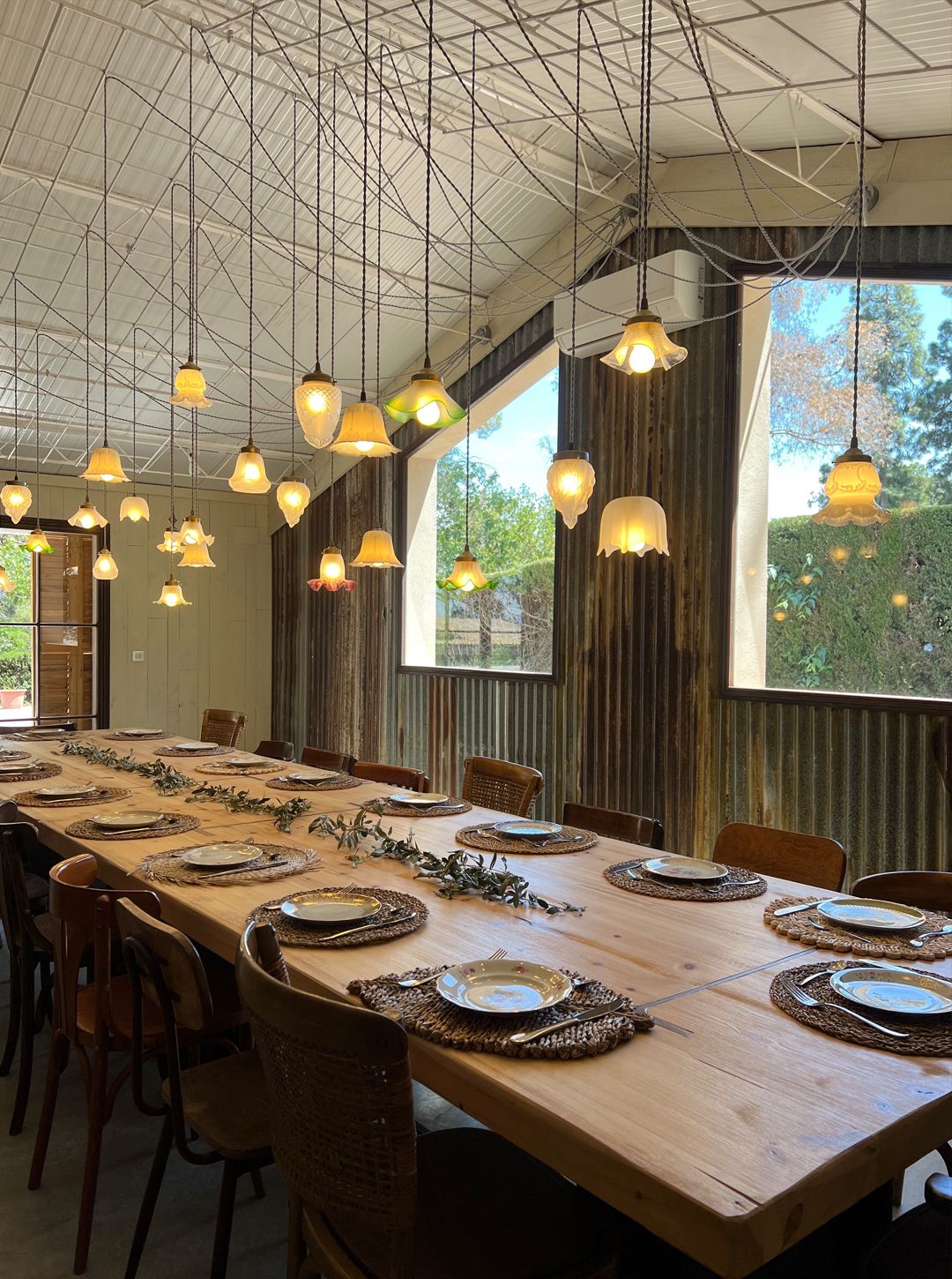 Long wooden table under glass lamps in the dining room at Bellesguart