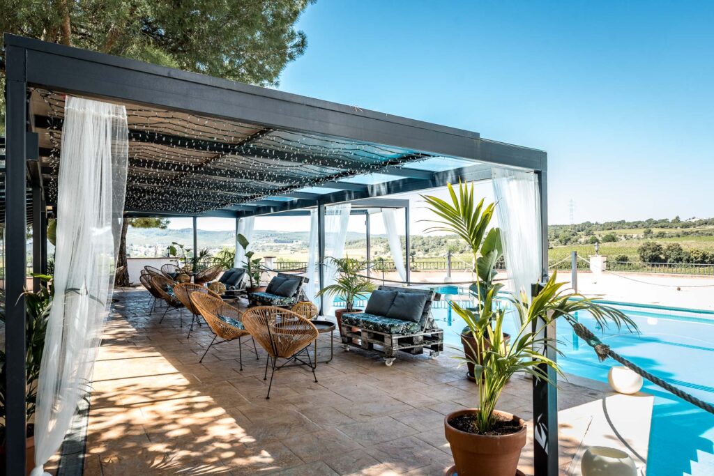 Pergola by the pool at Masia Torreblanca, overlooking the vineyards
